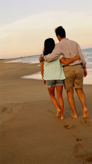 photo of a young couple strolling on a beach
